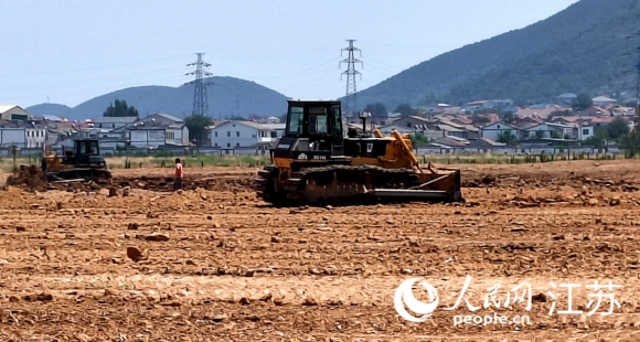 建筑垃圾被清理后，銅山區(qū)漢王鎮(zhèn)政府組織對土地平整，即將恢復農作物種植。人民網 閆峰攝