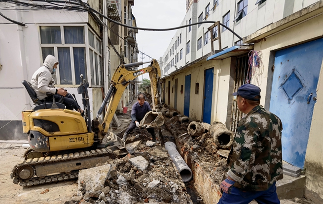 在東海縣實驗中學宿舍樓改造現(xiàn)場，施工隊正在有序地進行雨污分流設施安裝。東海縣委宣傳部供圖