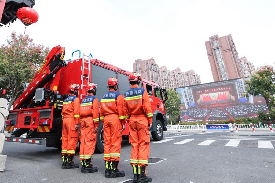 消防員在鹽城市鹽鎮(zhèn)水街前置備勤點觀看二十大開幕盛況。朱路杰攝