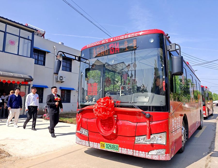 新郎走向公交婚車，幸福滿滿。丁華明攝