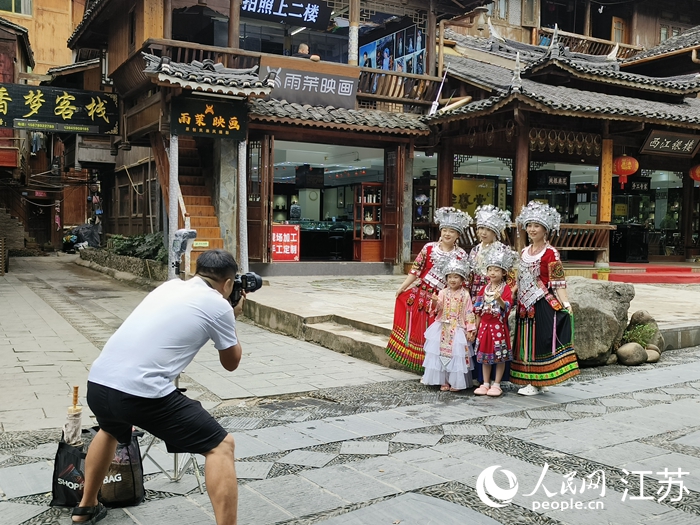 來(lái)自長(zhǎng)三角地區(qū)的游客穿上苗族服飾拍照留念。人民網(wǎng) 張瀚天攝